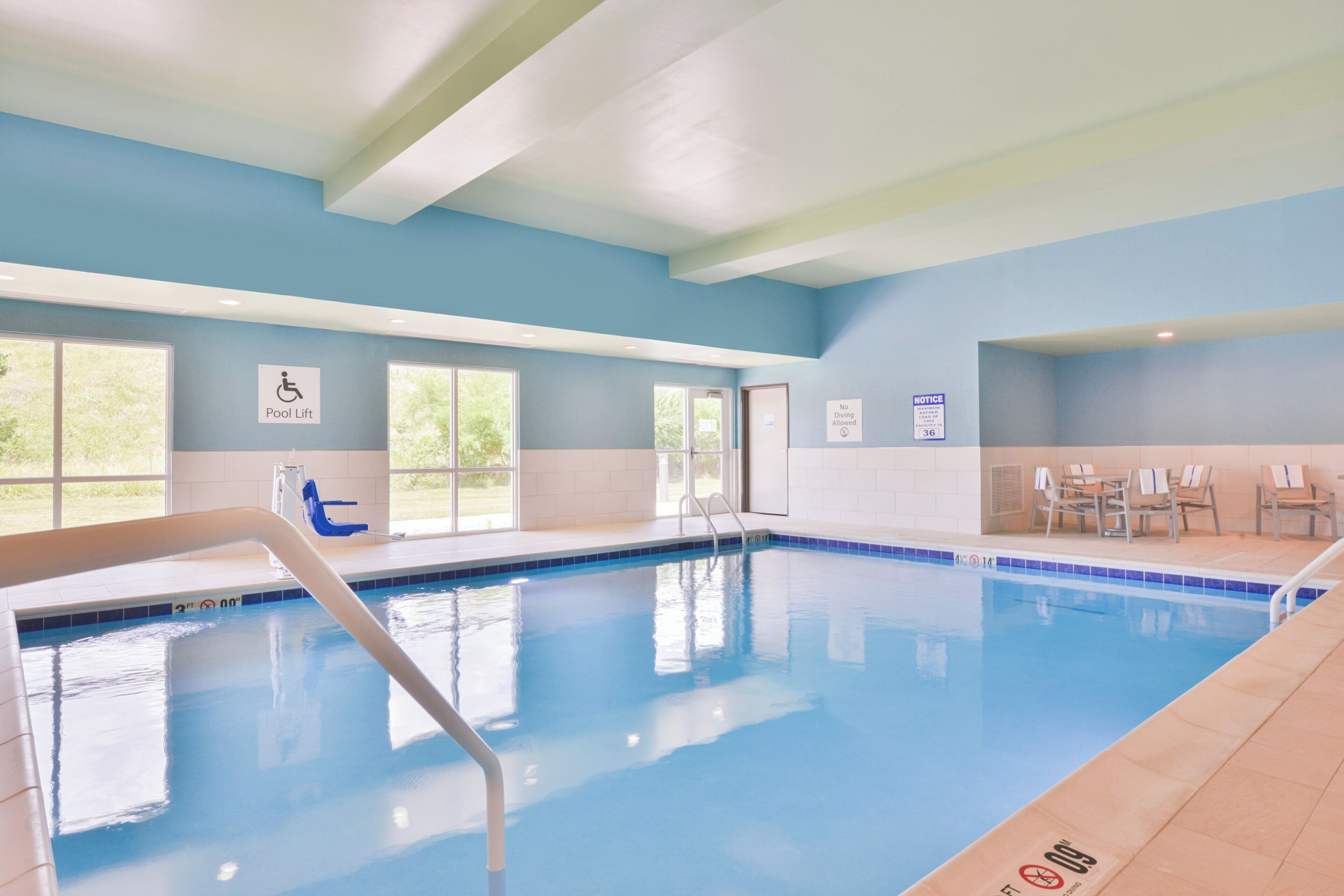 A swimming pool with a pool lift, lounge chairs, and a 'No Diving Allowed' sign.