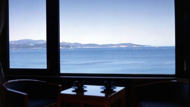 Una habitación con un gran ventanal con vistas a la costa.