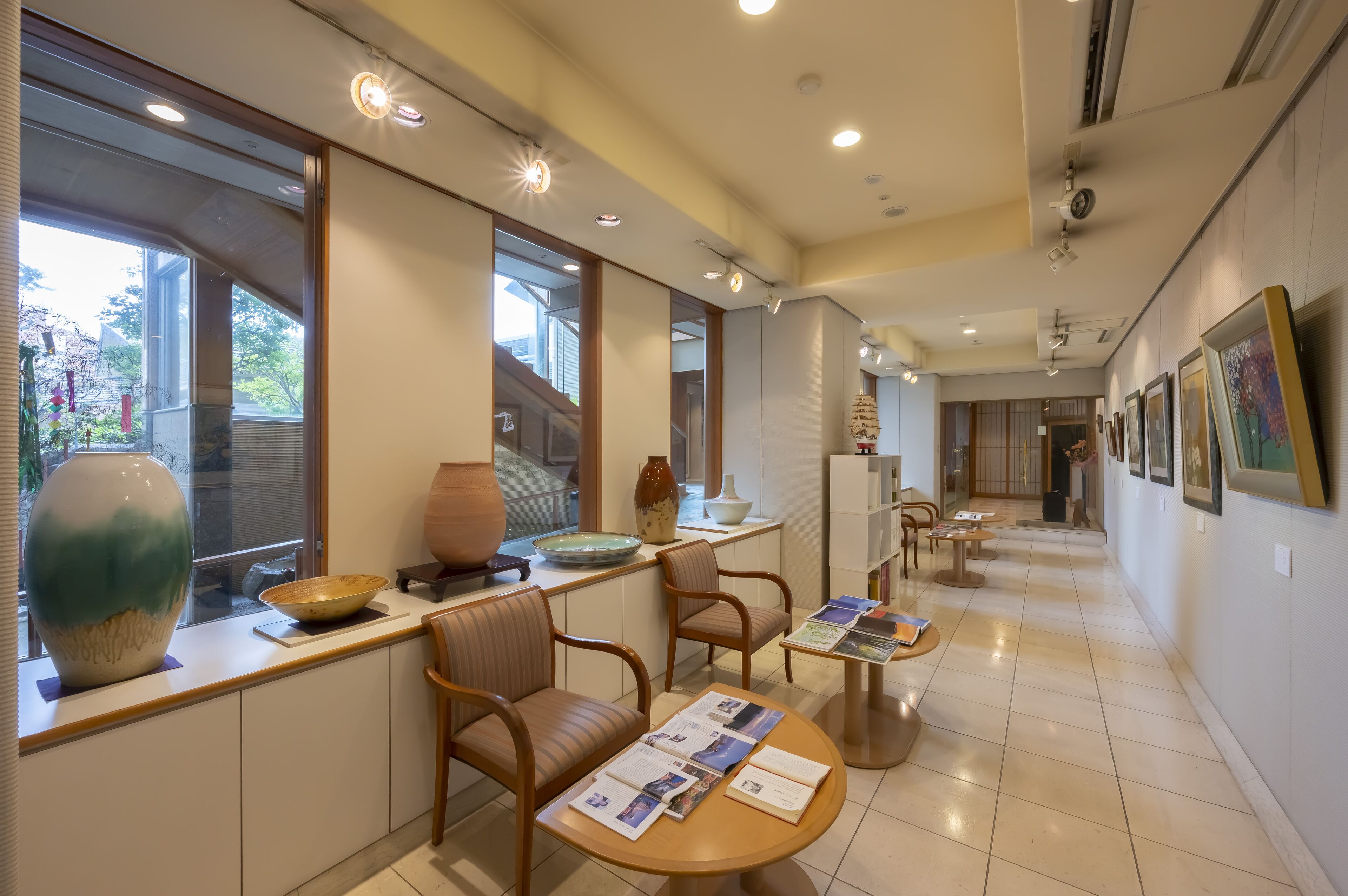 Un moderno vestíbulo de hotel con mostrador de recepción, zona de estar y obras de arte en las paredes.