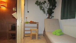 A cozy room with a wooden bench, a small table with a basket of fruit, and a green plant.