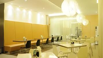 A modern interior with tables and chairs arranged for dining.
