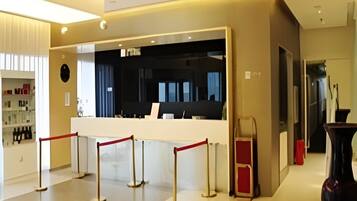 A reception area with a reception desk, a waiting area, and a counter with a red barrier.