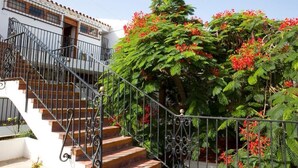 A staircase with ornate metal railings leading to a white building with a tiled roof. - Alsol Las Orquideas (San Bartolomé de Tirajana)