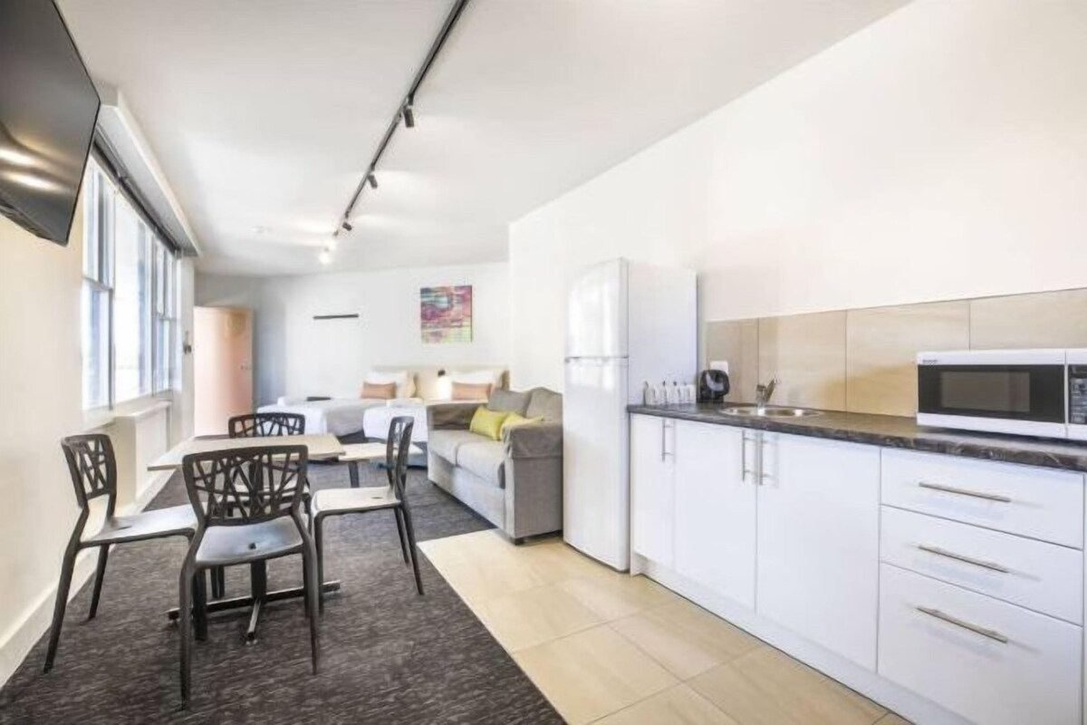A modern apartment with a kitchen, dining area, and living space.