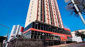 A tall hotel with a modern design, featuring a prominent red and white color scheme and large windows. - Hotel InterAmericana (Americana)
