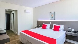 A modern hotel room with a large bed, a desk, and a nightstand. - Hotel InterAmericana (Americana)