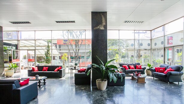 A spacious lobby with multiple seating areas, large windows, and indoor plants. - Hotel InterAmericana (Americana)