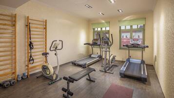 A gym with treadmills, an elliptical, a bench, and a squat rack.