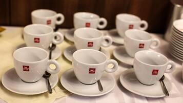 Una mesa con varias tazas y platillos blancos, cada uno con una cuchara y un logotipo.