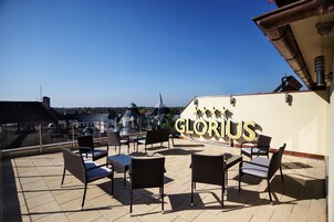 Terraza en la azotea con asientos al aire libre y vistas a edificios de la ciudad.