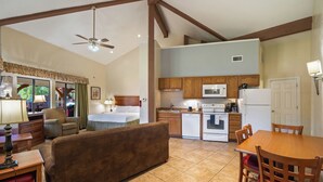 A compact living space with a kitchenette, a dining area, and a sofa. - Roundhouse Resort (Pinetop)