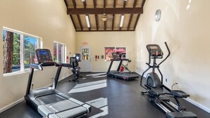 A gym with treadmills, an elliptical, and a stationary bike. - Roundhouse Resort (Pinetop)
