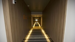 Un long couloir étroit aux murs en bois et au tapis à rayures.