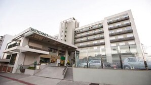 Un hôtel moderne doté d’une entrée imposante, de plusieurs étages et d’un espace de stationnement.