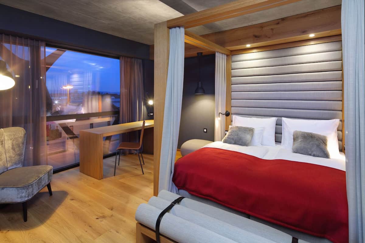 Un dormitorio moderno con cama, escritorio y silla.