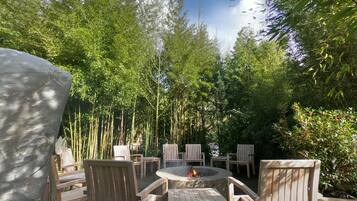 An outdoor seating area with wooden chairs and a fire pit.