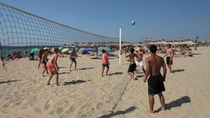 Ein Beachvolleyballspiel mit Spielern und Zuschauern.