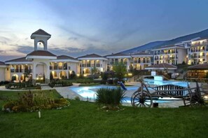 A resort with multiple buildings, a swimming pool, and a clock tower. - Monastery (Sveti Vlas)