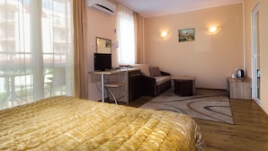 Ein Hotelzimmer mit Bett, Schreibtisch, Sessel und Blick nach außen.