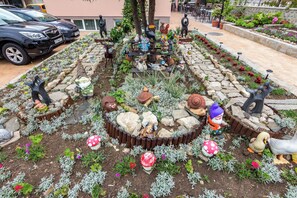 A garden with decorative statues and plants. - Family Hotel Venera (Nessebar)