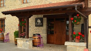 Een stenen gebouw met een houten deur en een bord waarop 'el Cobo Restaurant' staat.