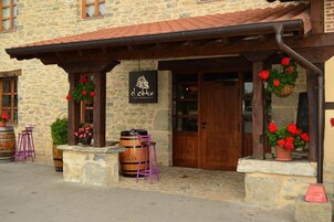 Un edificio de piedra con una puerta de madera y un letrero que dice "el Cobo Restaurant".