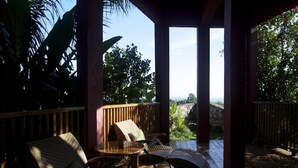 An outdoor deck with wicker furniture and a view of the landscape. - Da Fabio (Negril)