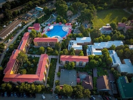 Oversigtsbillede af et boligområde med en swimmingpool omgivet af huse og grønt.