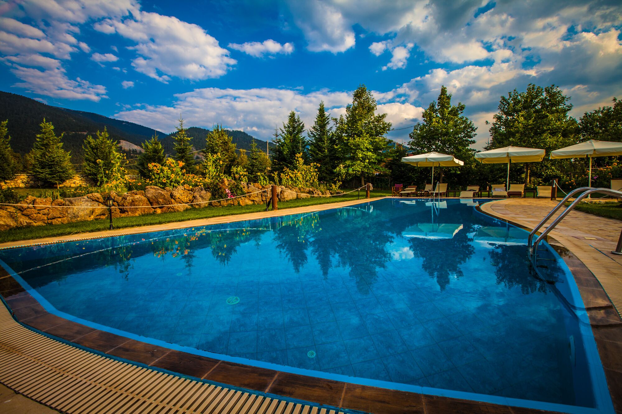 حمّام سباحة خارجي موسمي، مظلات على حمّام السباحة، مقاعد للتشمس