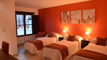 A hotel room with two beds, a window, and artwork on the wall.