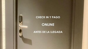Uma porta com teclado numérico e instruções para check-in online e pagamento antes da chegada.