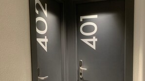 Um corredor com duas portas, cada uma delas numerada.