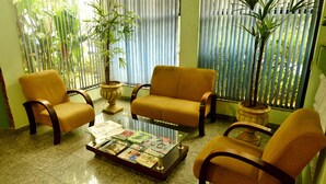 A seating area with two sofas and two armchairs, a glass coffee table with magazines, and two potted plants. - Hotel Pantanal Chácara Klabin (São Paulo)