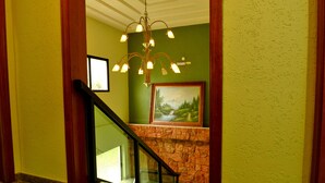 A staircase with a stone wall and a framed painting above it. - Hotel Pantanal Chácara Klabin (São Paulo)