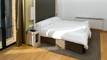 Un dormitorio con cama, mesita de noche y vistas al exterior.