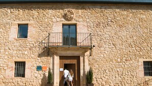 A stone building with a balcony, a wooden door, and two windows. - Hospedium Hotel Convento Santa Ana (Atienza)
