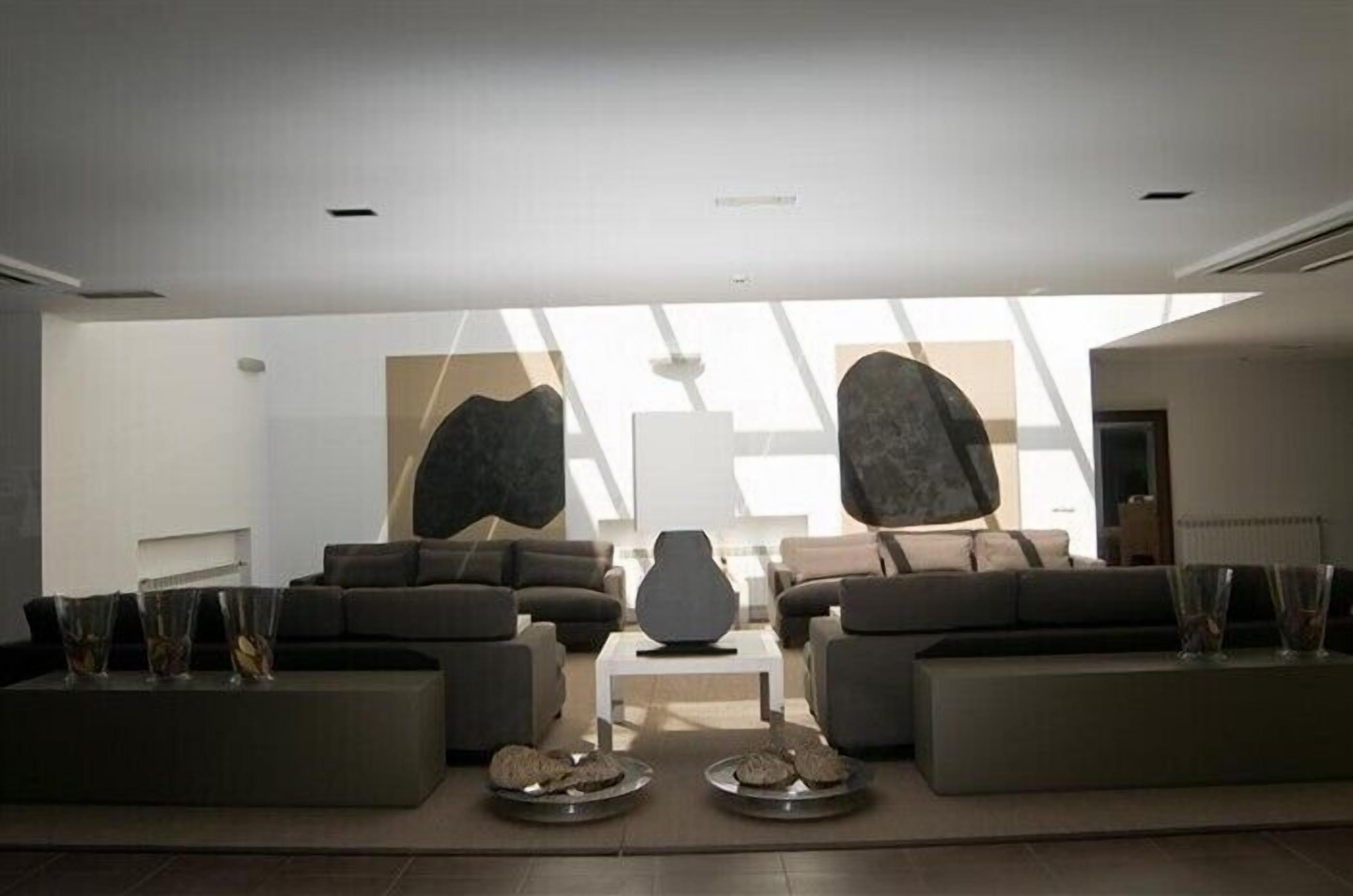 Una sala de estar moderna con un conjunto de sofá, una mesa de centro y jarrones decorativos.