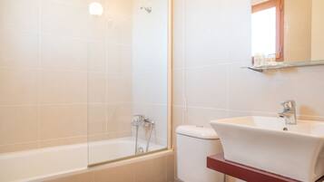 Un baño con bañera, inodoro y lavamanos.