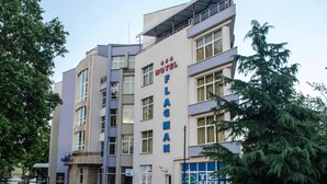 Un hôtel à plusieurs étages au design moderne, reconnaissable à son enseigne bien visible indiquant « Hôtel Flaming ».