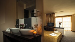 Un baño de hotel con dos lavamanos, un espejo y un secador de pelo montado en la pared.