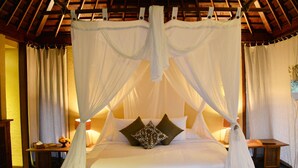 A bedroom with a canopy bed, a wooden ceiling, and bedside tables with lamps. - Nusabay Menjangan by WHM (Sumberklampok)