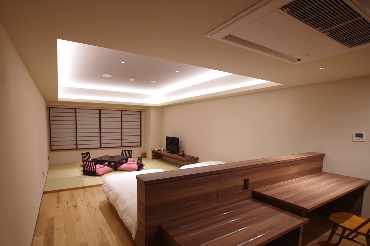 Une chambre à coucher moderne avec un lit, un bureau et un téléviseur.