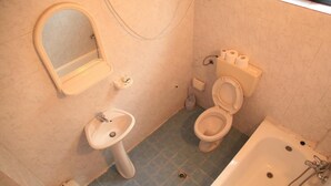 A bathroom with a toilet, sink, and bathtub.