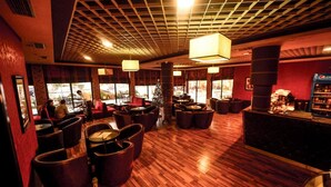 A restaurant with wooden flooring, red walls, and a bar area.