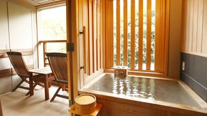 A traditional Japanese-style room with tatami flooring, a wooden hot tub, and sliding doors. - Mizunoto (Hakone)