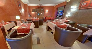 Enjoy meals in a warm, inviting dining area with comfortable seating and elegant decor.
