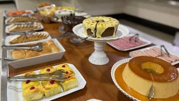 Una mesa de buffet con diversos postres, incluyendo un flan, un pastel de caramelo y un pastel de queso.
