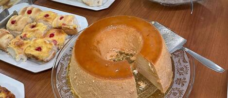 Una mesa de buffet con diversos productos de pastelería y un pastel grande.