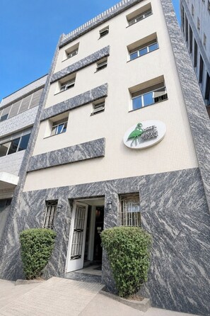 Un hôtel doté d’une façade moderne, de nombreuses fenêtres et d’un logo sur la devanture.