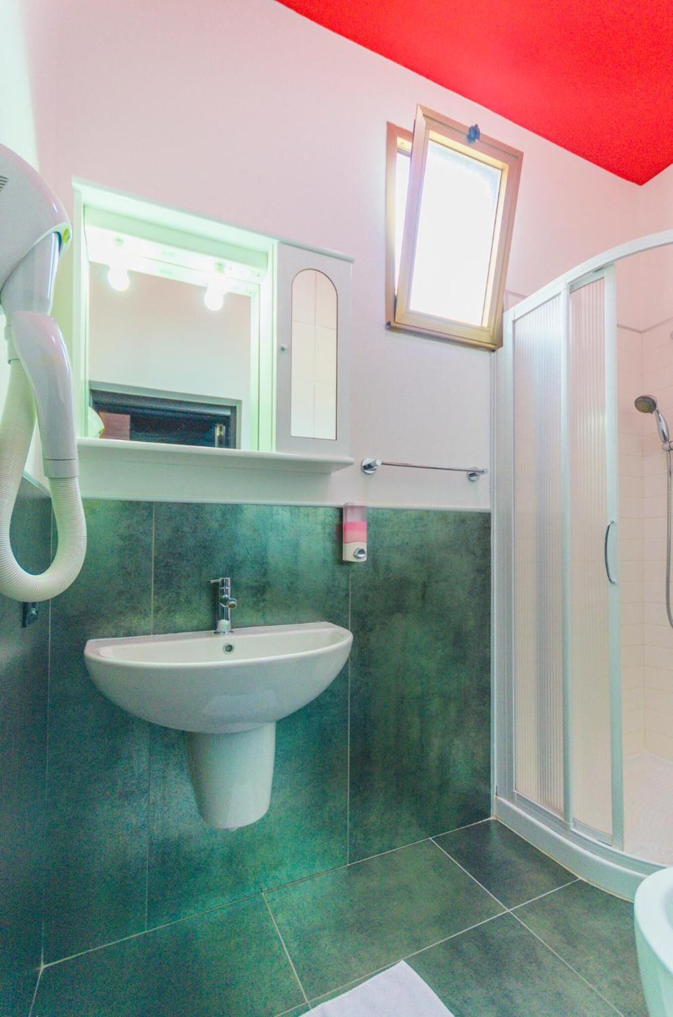 Un baño con lavabo, espejo y ducha.